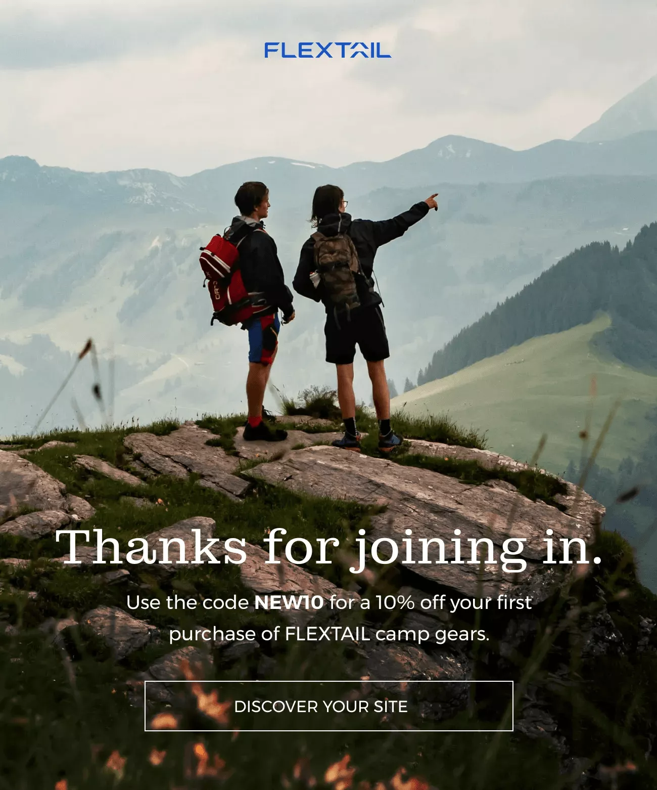 Email automation: Two hikers with backpacks stand on a grassy mountain ridge overlooking distant hills. Text offers 10% off FLEXTAIL camp gear with code NEW10 for first-time purchases. Button reads Discover Your Site.