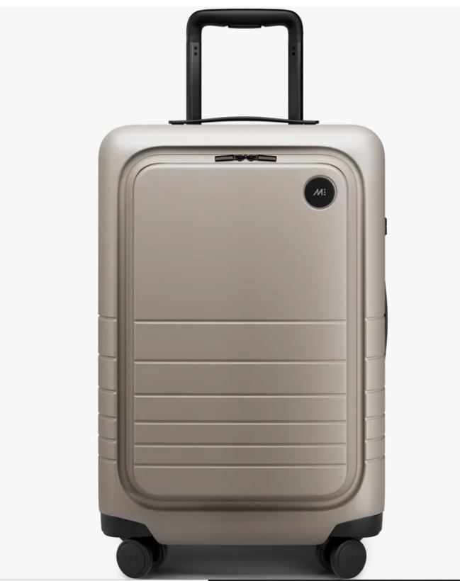 Most profitable products to sell online: A beige hard-shell suitcase with four wheels, a front compartment, a black circular logo near the top right corner, and a black telescopic handle extended.