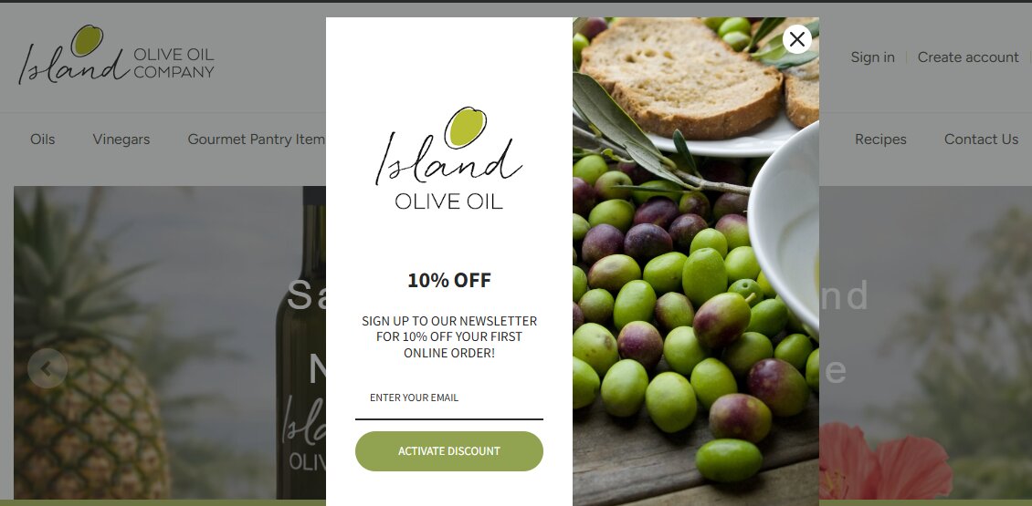 Email capture: A pop-up window on the Island Olive Oil Company website offers 10% off the first online order for signing up for their newsletter. Olives, bread, and olive oil are visible in the background.