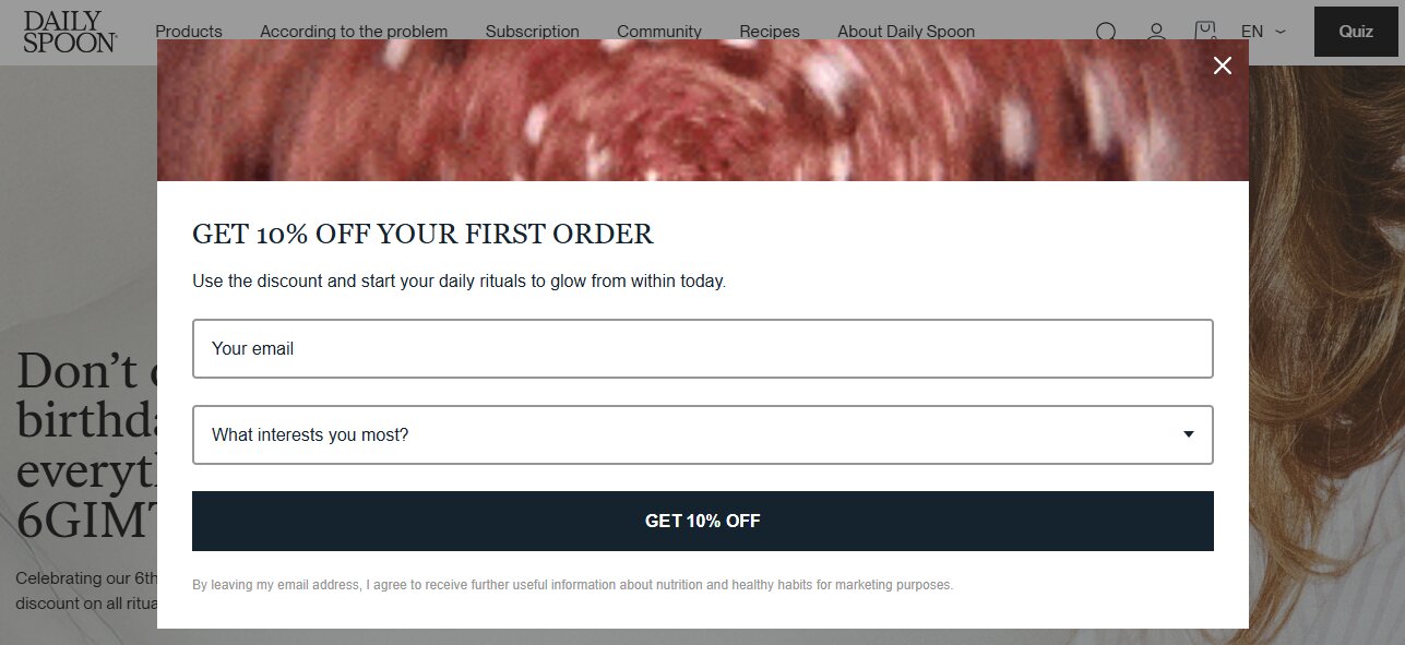 Email capture: Pop-up on a website offering 10% off the first order, with fields to enter an email address and select an interest, and a button labeled GET 10% OFF. The background is partially blurred.