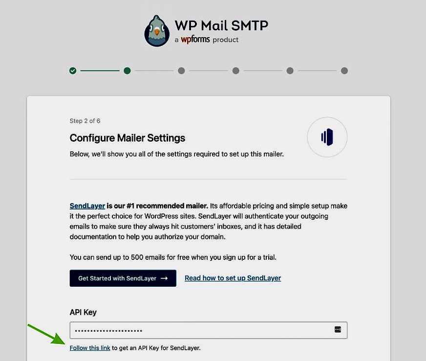 WordPress emails going to spam: Screenshot of the WP Mail SMTP setup, showing the Configure Mailer Settings step with instructions to get an API key for SendLayer. A green arrow points to a link labeled Follow this link to get an API Key for SendLayer.