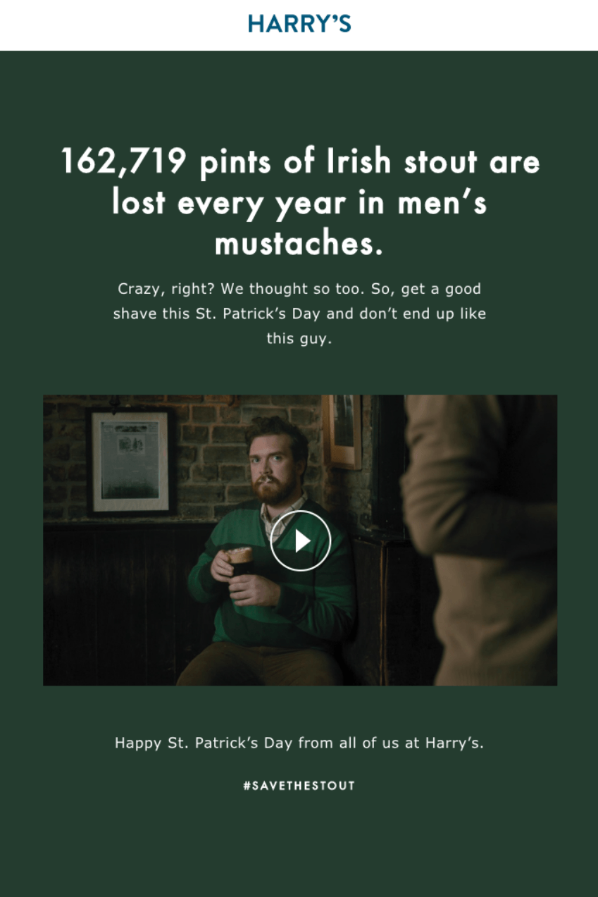 Video email marketing: A man with a beard sits at a table holding a pint of stout, with foam on his mustache. The text above highlights how much stout gets lost in men’s mustaches each year. St. Patrick’s Day greeting from Harry’s.