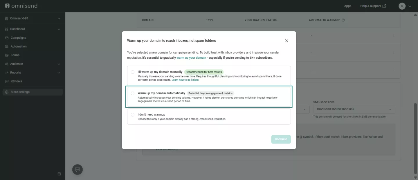 Shopify emails going to spam: A screenshot of an Omnisend interface showing a pop-up window with options to warm up a domain manually, automatically, or not at all, to improve email deliverability. The automatically option is selected.