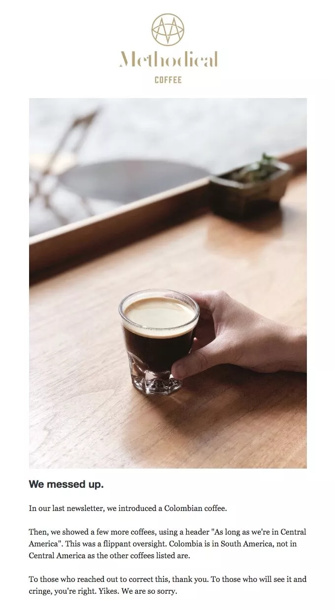 Funny email examples: A hand holds a glass of coffee on a wooden table next to a small potted plant. Text below explains a correction about incorrectly labeling Colombia as being in Central America in a previous newsletter.