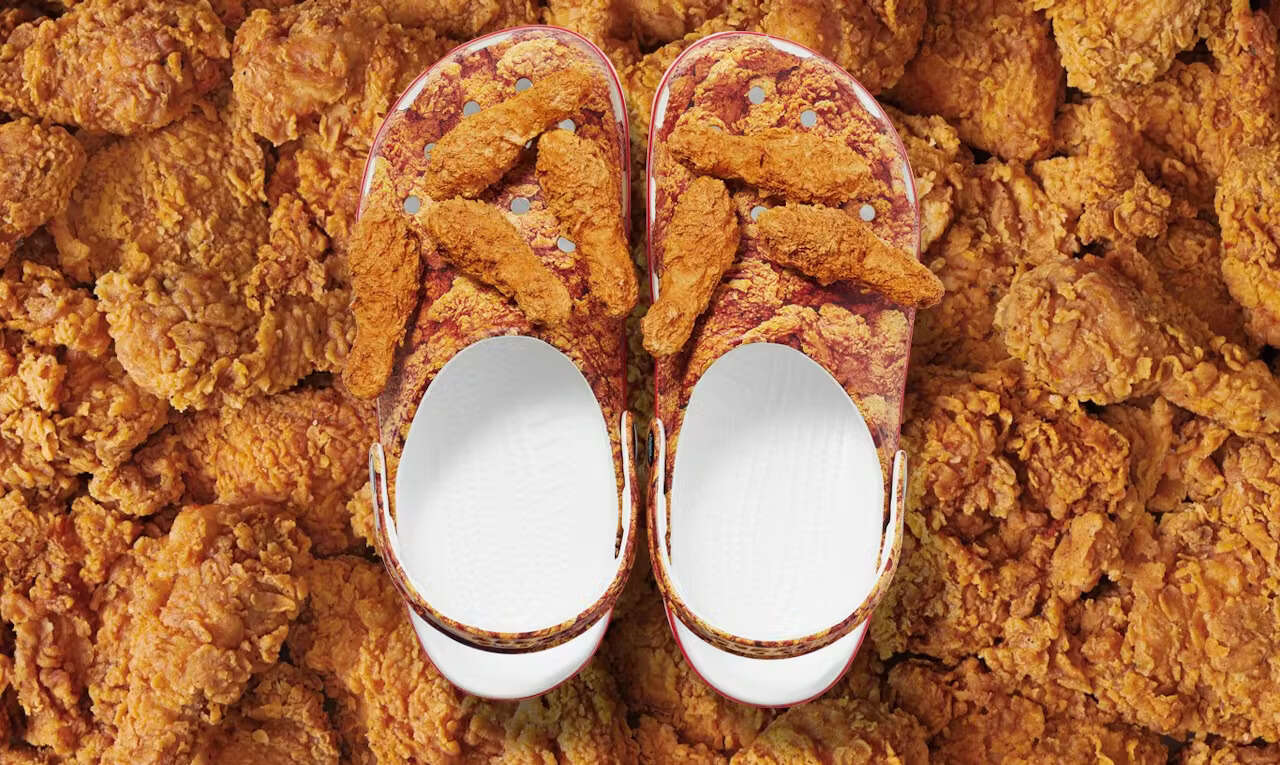 Guerilla marketing: A pair of Crocs designed to look like fried chicken, with a fried chicken drumstick as decoration, placed on a background covered in fried chicken pieces.