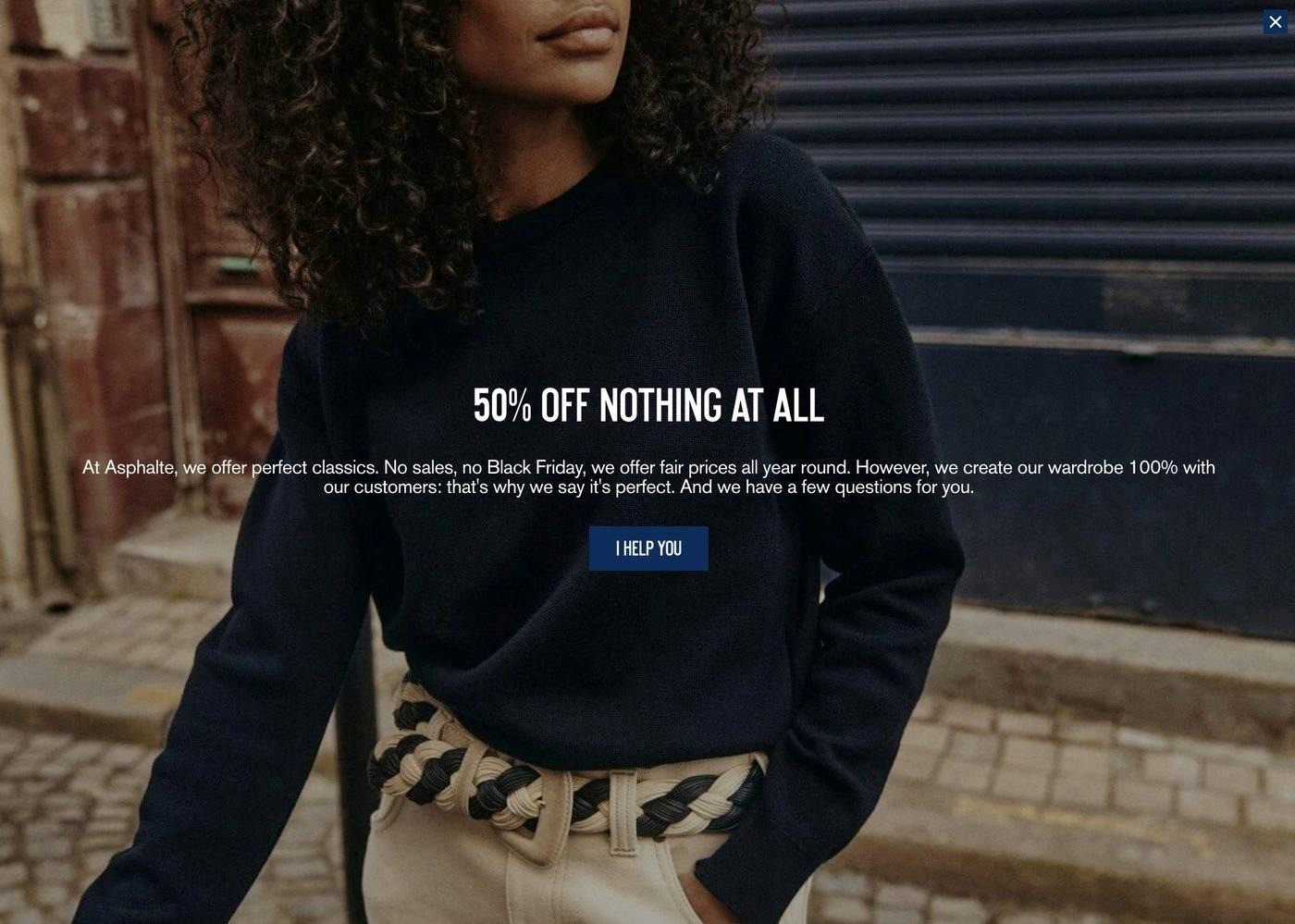 Black friday popup: A person in a navy sweater and beige pants stands on a cobblestone street. Text overlay reads 50% OFF NOTHING AT ALL with a message about fair pricing and a blue I HELP YOU button below.