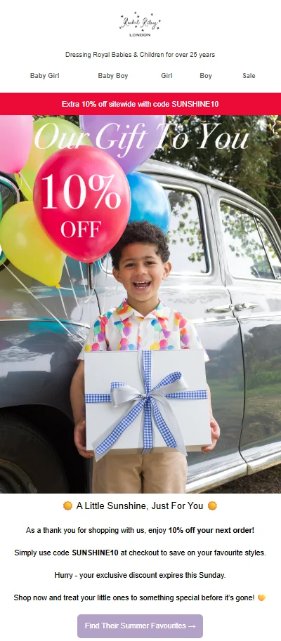 Black Friday marketing: Smiling boy holding a large gift box with a blue ribbon, standing in front of a classic car with colorful balloons and a 10% Off sign.