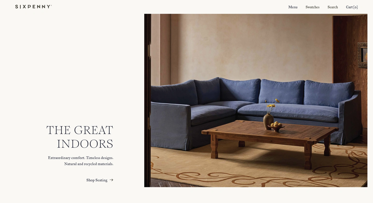 Blue sectional sofa and wooden coffee table in a neutral-toned living room with beige patterned rug.