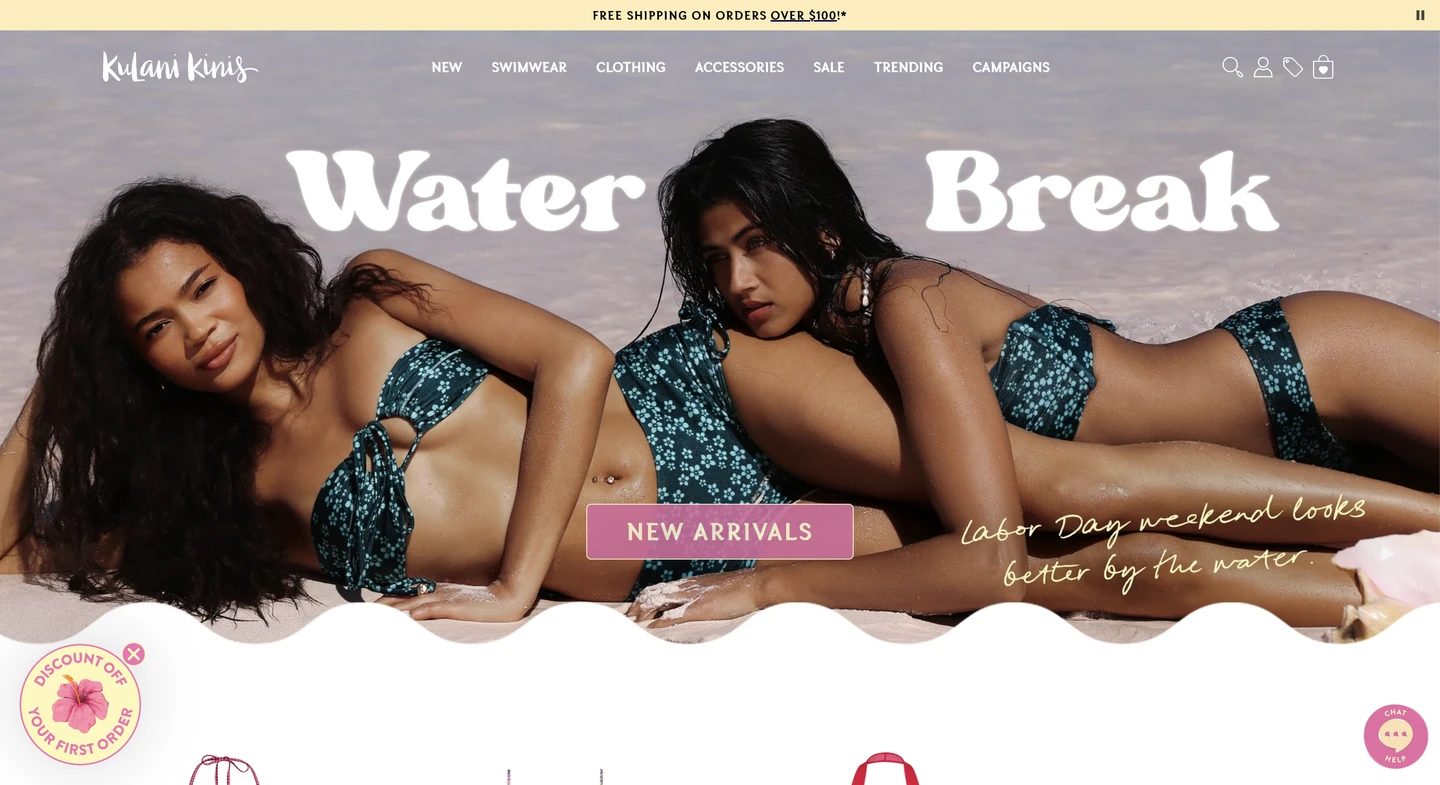 Two women in matching blue bikinis pose on a beach for a swimwear brands Water Break new arrivals campaign.