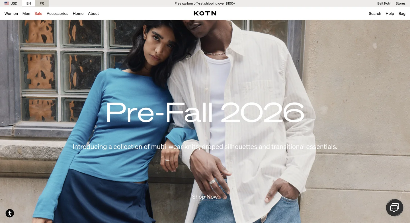 Two models pose together in casual pre-fall outfits in front of a window and stone wall, with Pre-Fall 2026 text overlay.