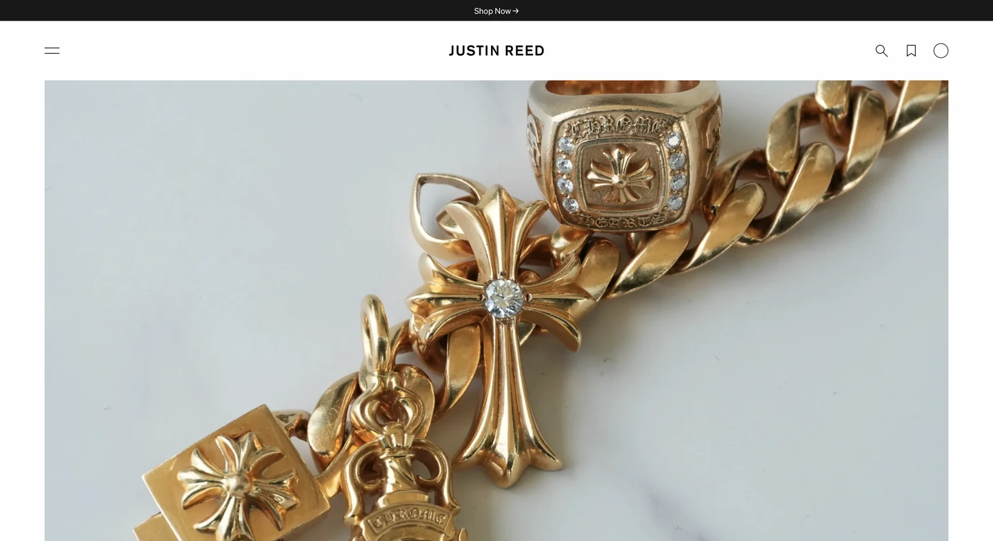 Gold jewelry including a chain, rings, and cross pendants displayed on a white surface.